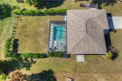 an aerial view of a house with a yard and lake view