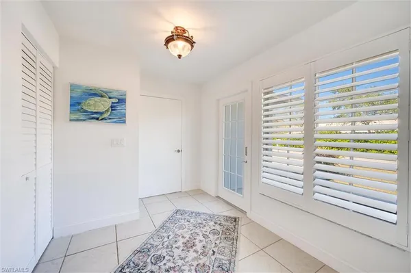 a view of empty room with window and wooden floor