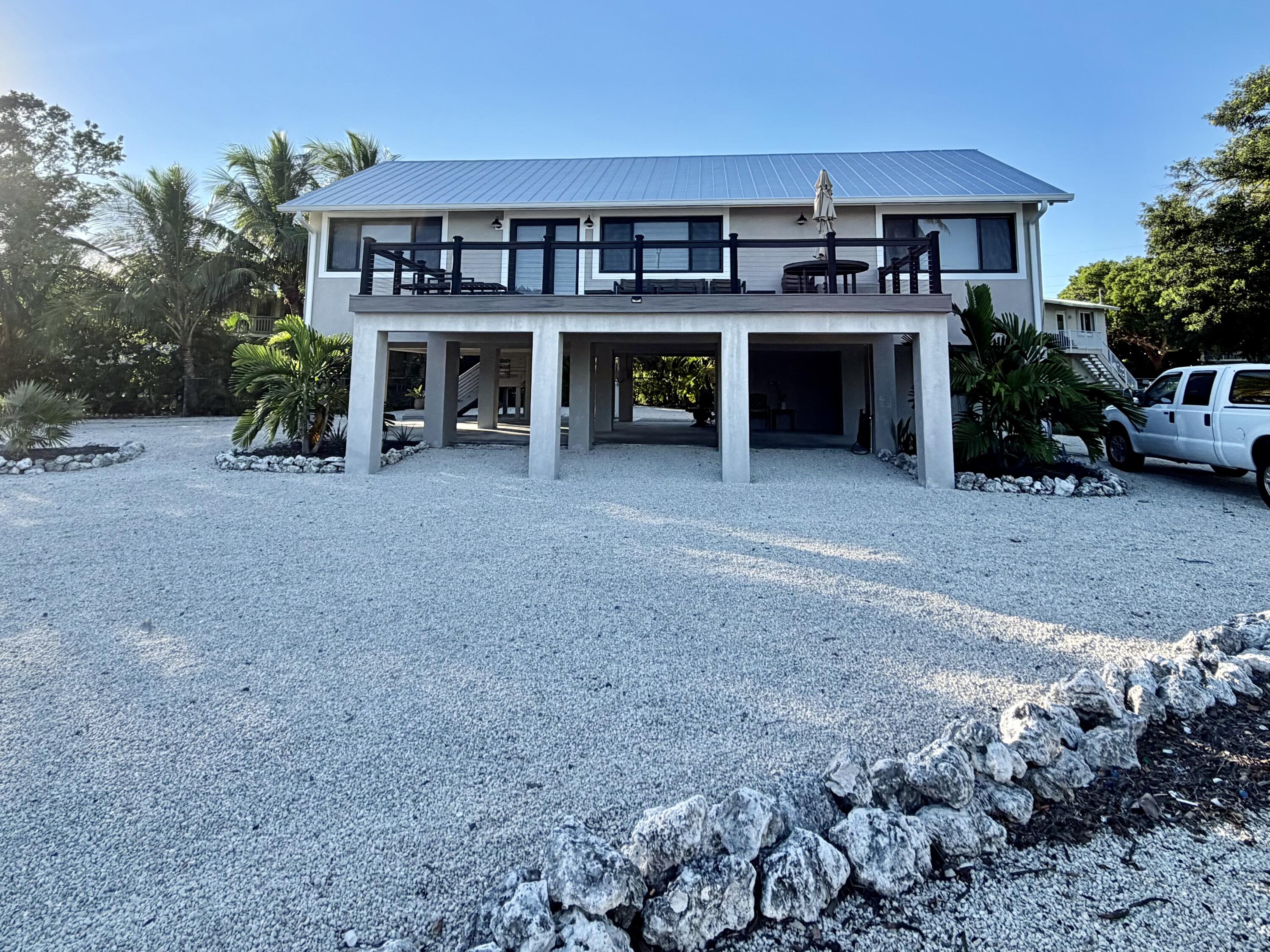 341 Sunset Drive Key Largo, FL 33037 - Photo 3 of 19 a view of house with a yard and a car park in front of it