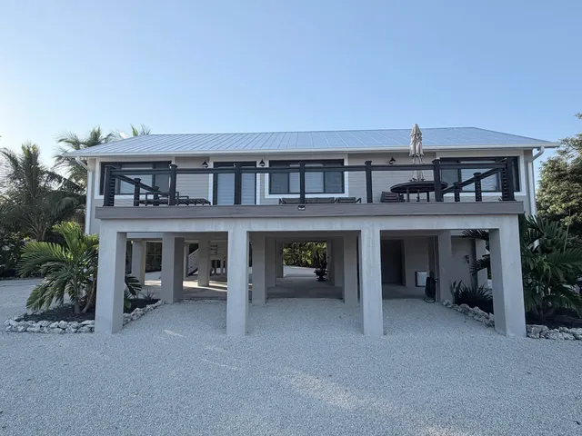 a view of a house with a balcony and seating space