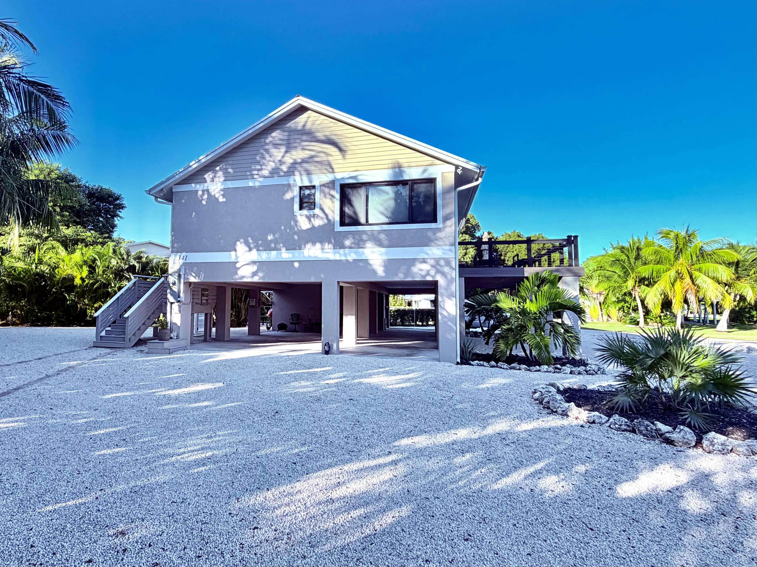 341 Sunset Drive Key Largo, FL 33037 - Photo 5 of 19 a front view of a house with a yard and a garage