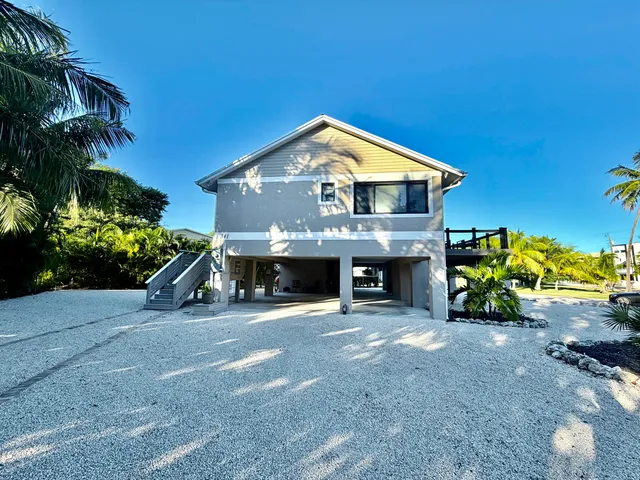a view of a house with a yard and potted plants