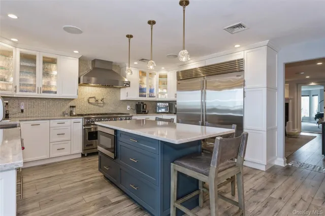 a kitchen with stainless steel appliances granite countertop a sink a stove and a wooden floors