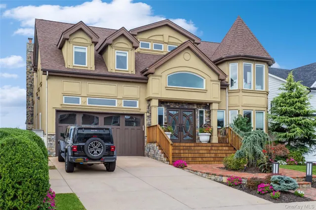 a view of a white house with large windows and a table and chairs
