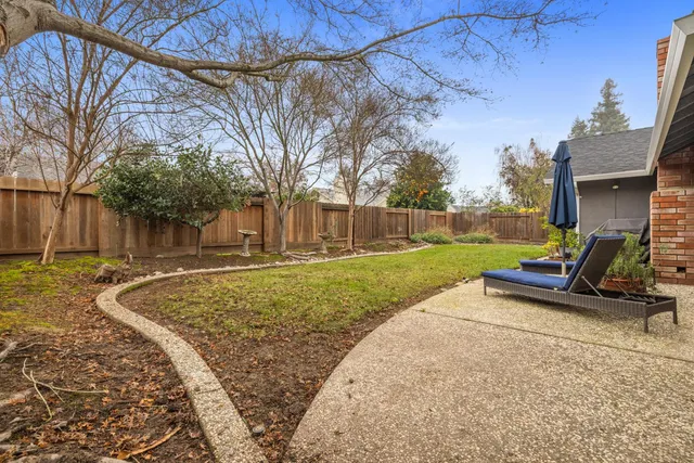 a view of a house with backyard and a tree