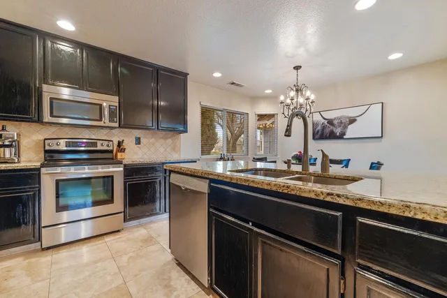 a kitchen with stainless steel appliances granite countertop a sink and stove top oven