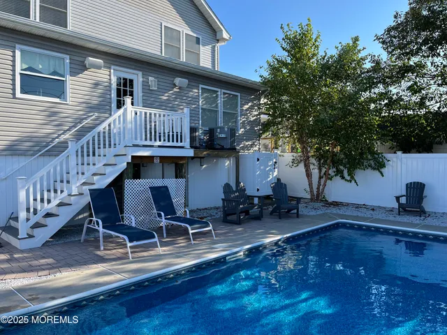 a view of a house with pool and sitting area