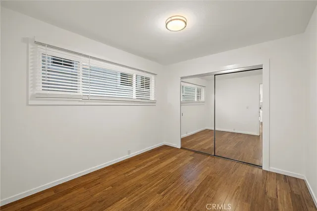 a view of a room with wooden floor and a window