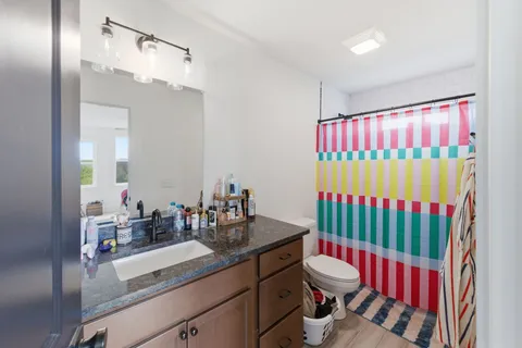 a bathroom with a sink vanity mirror and toilet
