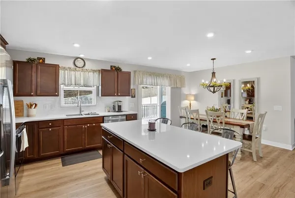 a kitchen with a stove a sink a refrigerator a center island and furniture