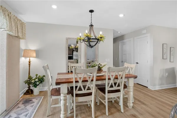 a dining room with chandelier and wooden floor