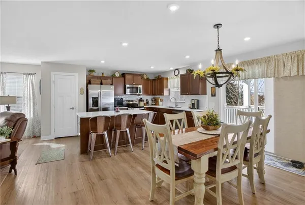 a kitchen with stainless steel appliances kitchen island granite countertop a refrigerator a stove a kitchen island with a dining table and chairs