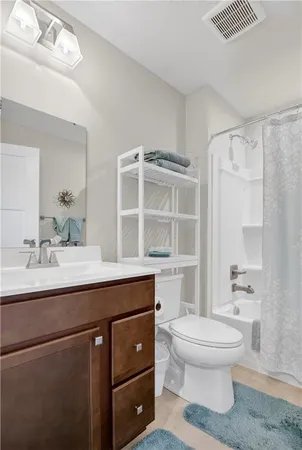 a bathroom with a sink toilet vanity and shower