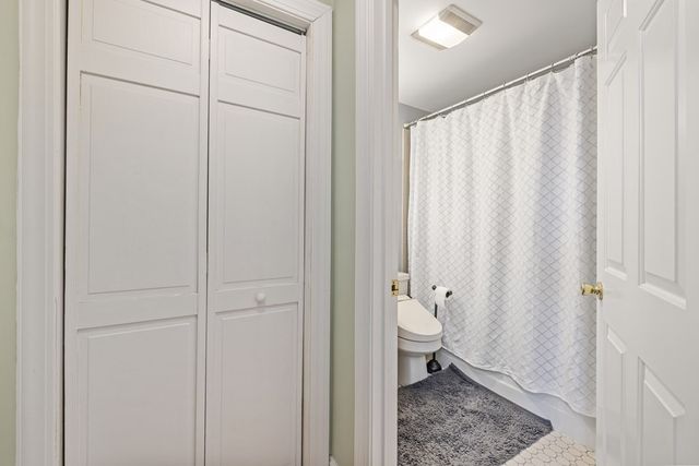 a bathroom with a granite countertop sink and a toilet