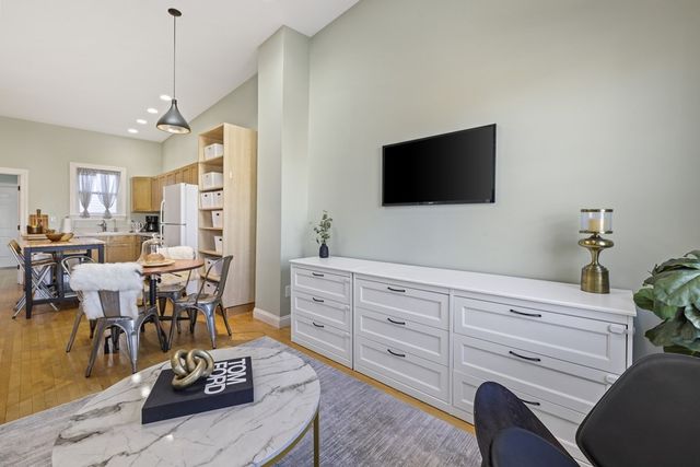 a living room with furniture a flat screen tv and a potted plant
