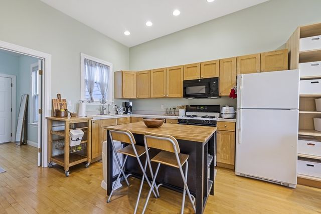 a kitchen with a refrigerator a table and chairs