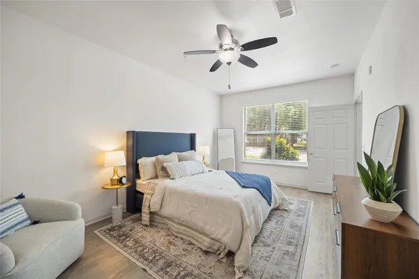 a bedroom with a bed a couch and a potted plant