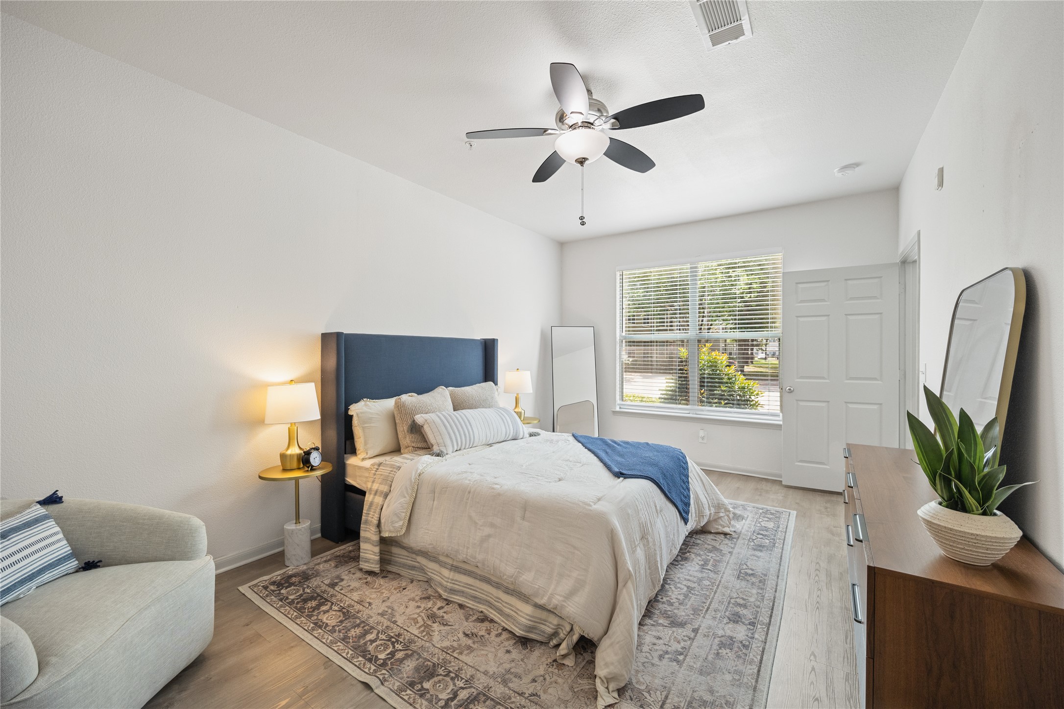 9494 Humble Westfield Road, Unit 934 Humble, TX 77338 - Photo 15 of 22 a bedroom with a bed a couch and a potted plant