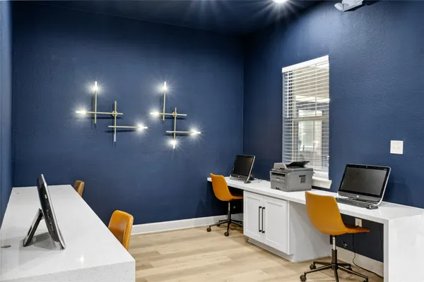 a view of a workspace with furniture and a window