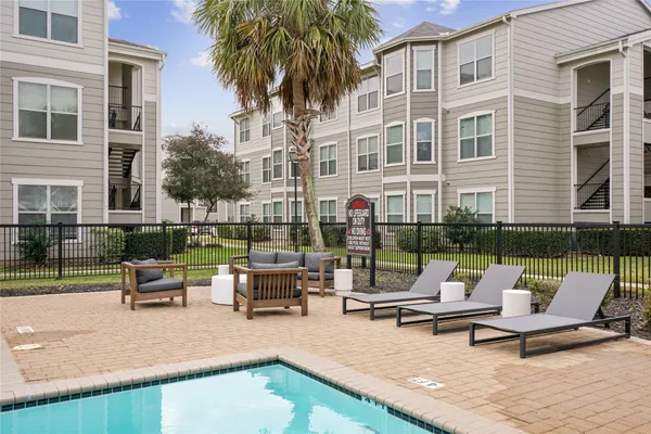a swimming pool with outdoor seating and barbeque oven