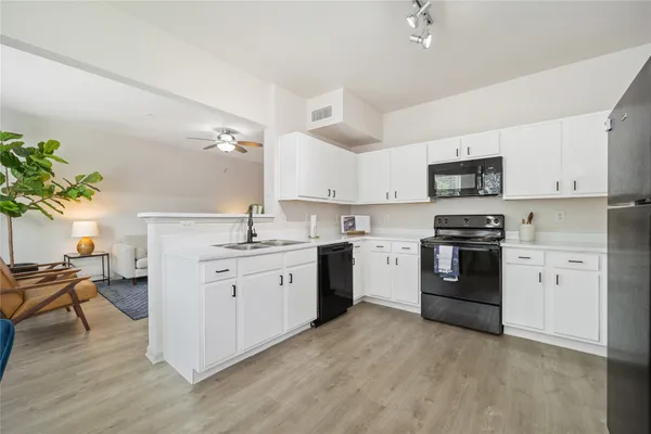 a kitchen with sink a microwave and cabinets