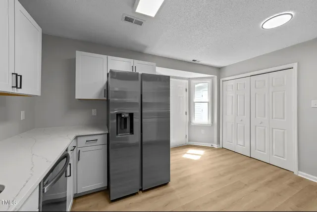 a kitchen with stainless steel appliances granite countertop a refrigerator and a sink