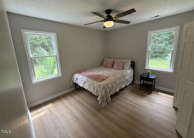 a bed sitting in a bedroom next to a window