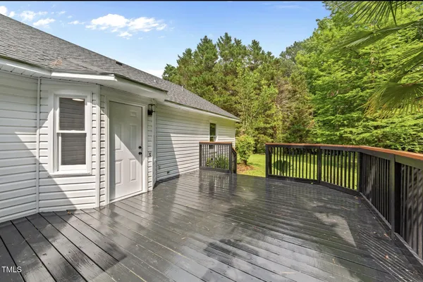 a view of a deck with wooden floor and fence with a large garden