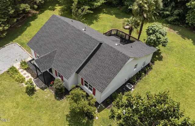 an aerial view of a house with a yard and lake view