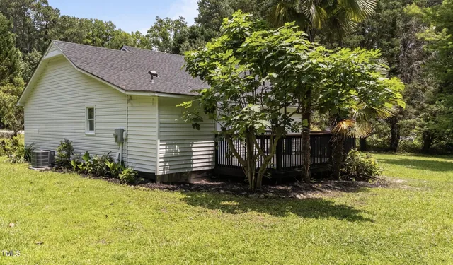 a view of backyard of house with green space