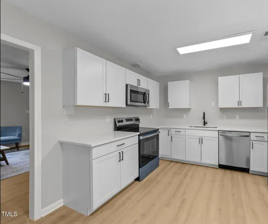 a kitchen with granite countertop appliances cabinets and a sink