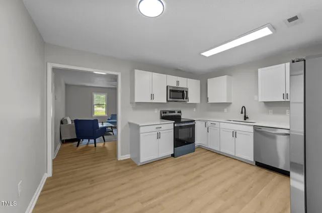 a kitchen with a refrigerator stove top oven and sink