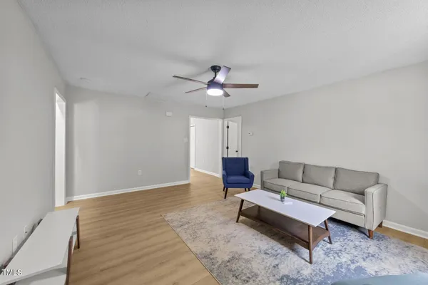 a living room with furniture and a ceiling fan