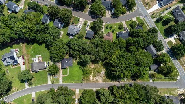 an aerial view of residential house with outdoor space and trees all around