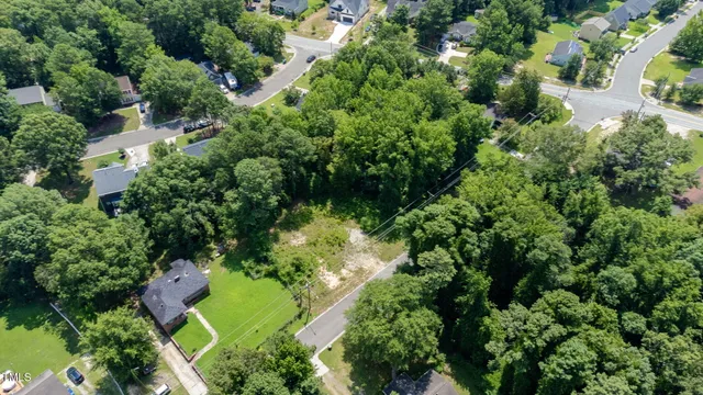 an aerial view of residential house with outdoor space and trees all around
