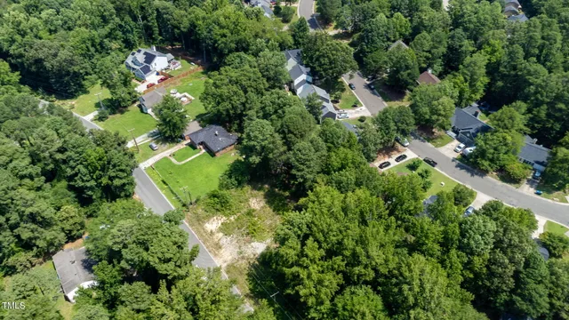 an aerial view of residential house with outdoor space and trees all around