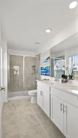a bathroom with a double vanity sink toilet and shower