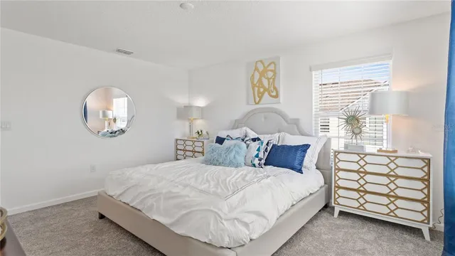 a bedroom with a bed a chandelier and a window