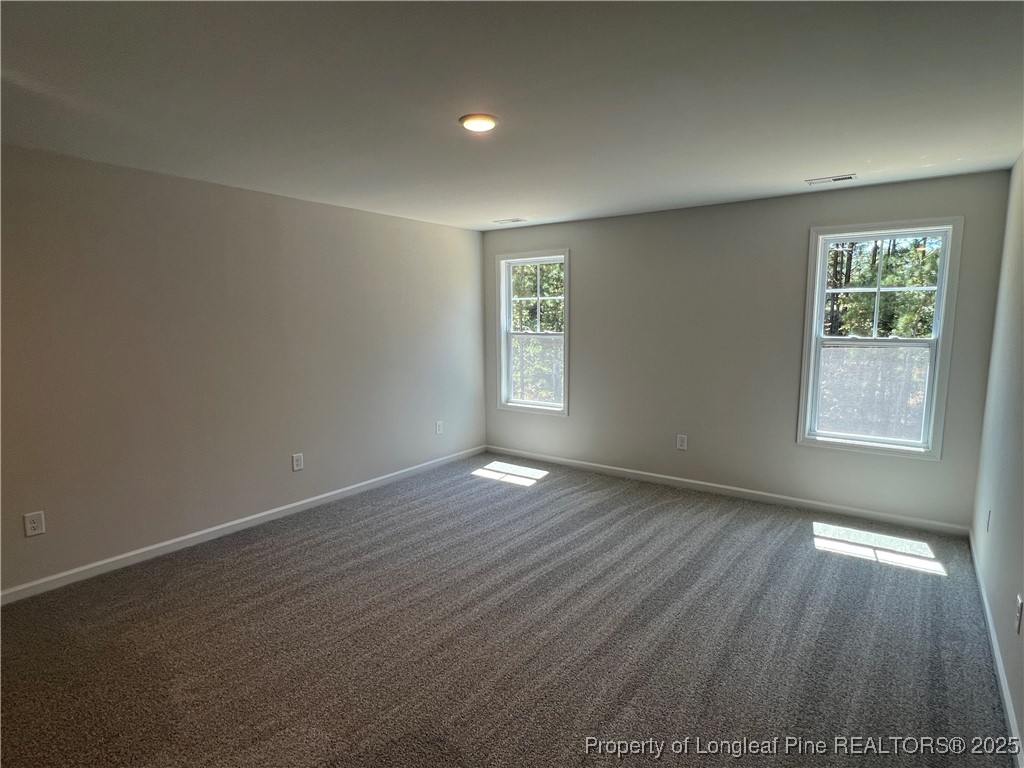 528 Traveller Way Raeford, NC 28376 - Photo 12 of 23 an empty room with wooden floor and windows