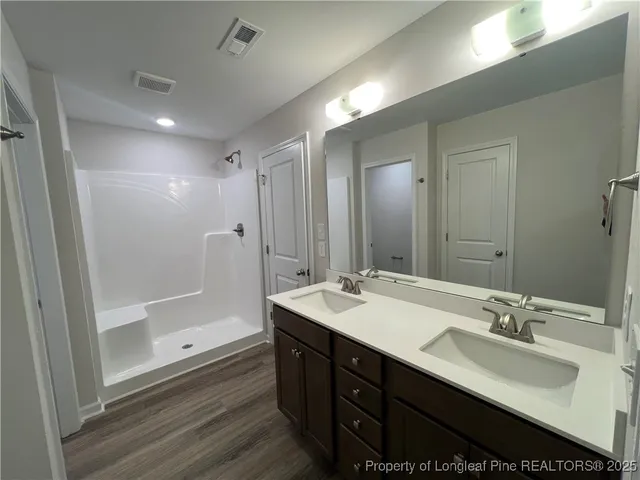 a bathroom with a double vanity sink mirror double shower and a bathtub