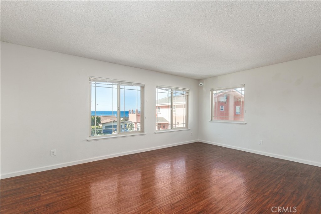 2023 Circle Cayucos, CA 93430 - Photo 20 of 44 an empty room with wooden floor and windows