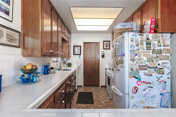 a kitchen with stainless steel appliances kitchen island granite countertop a refrigerator and a stove