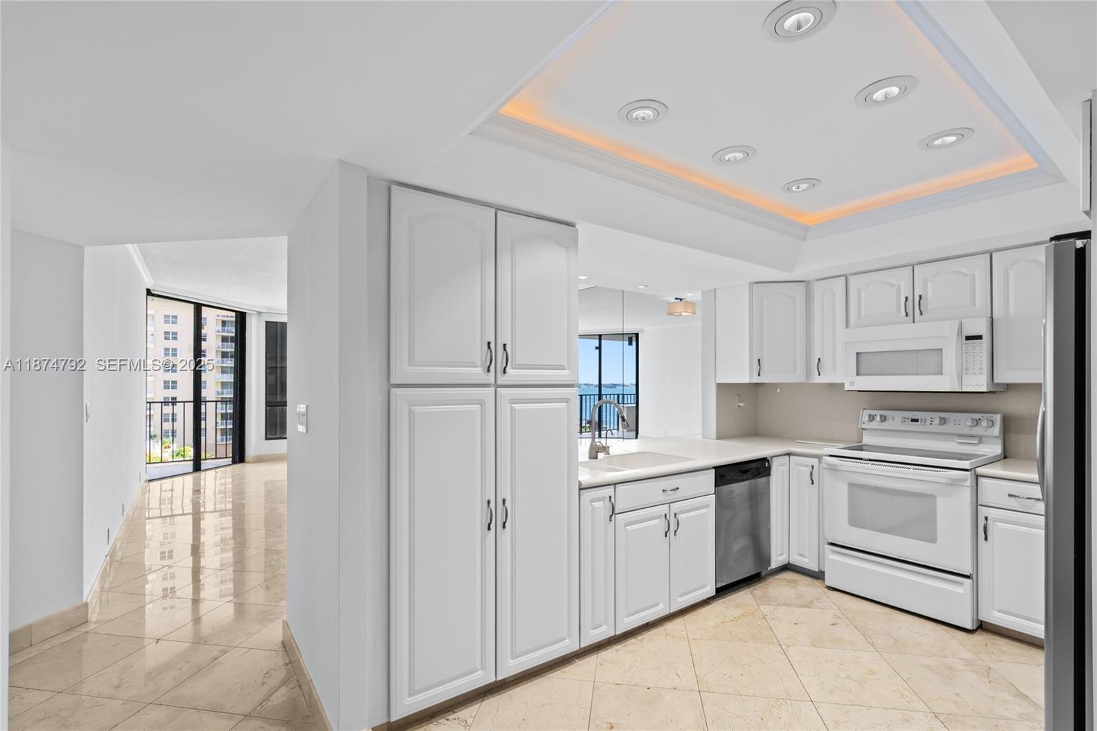 520 Brickell Key Drive, Unit A705 Miami, FL 33131 - Photo 12 of 63 a kitchen with white cabinets and white appliances