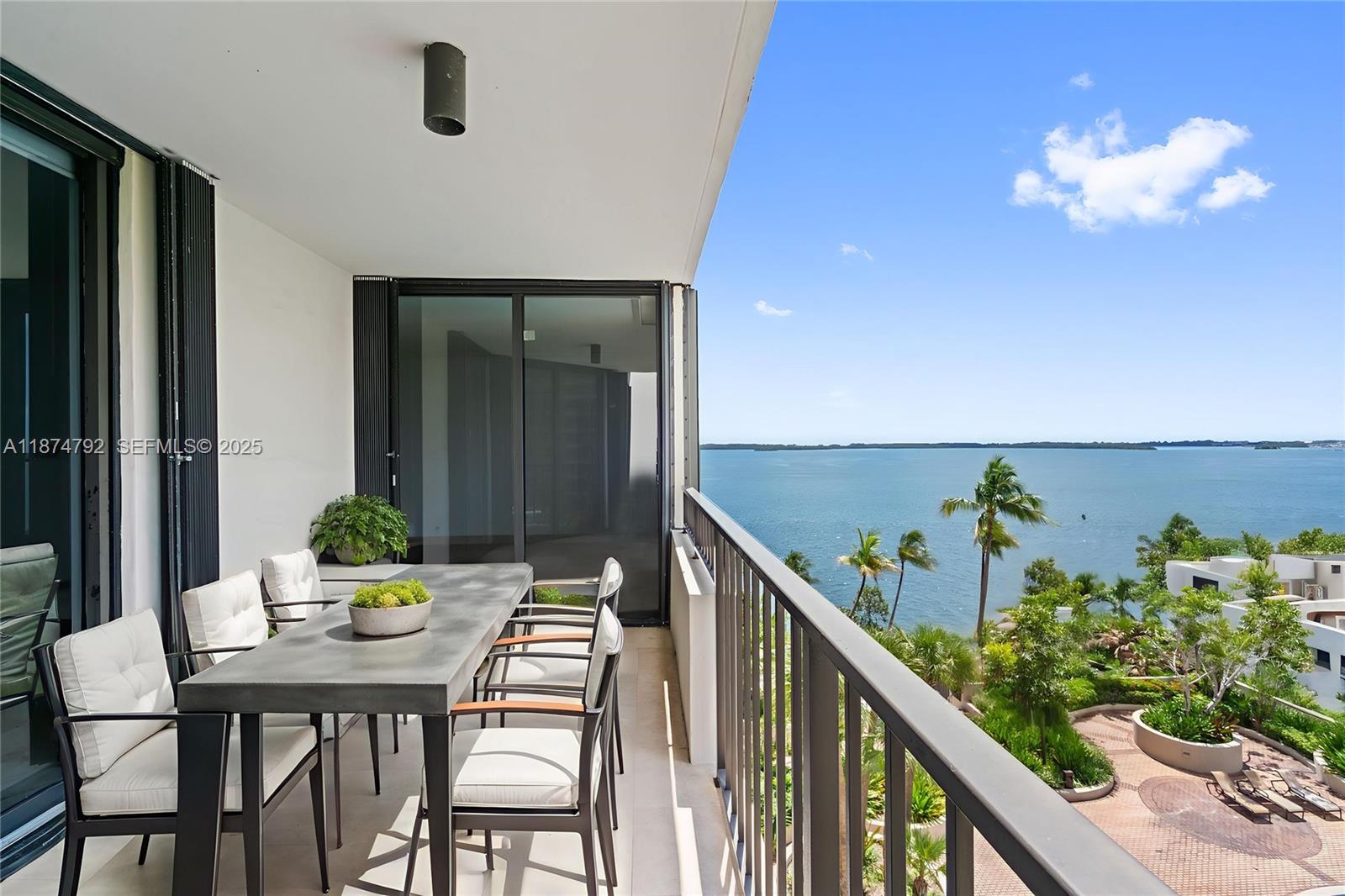 520 Brickell Key Drive, Unit A705 Miami, FL 33131 - Photo 3 of 63 a balcony with wooden floor table and chairs