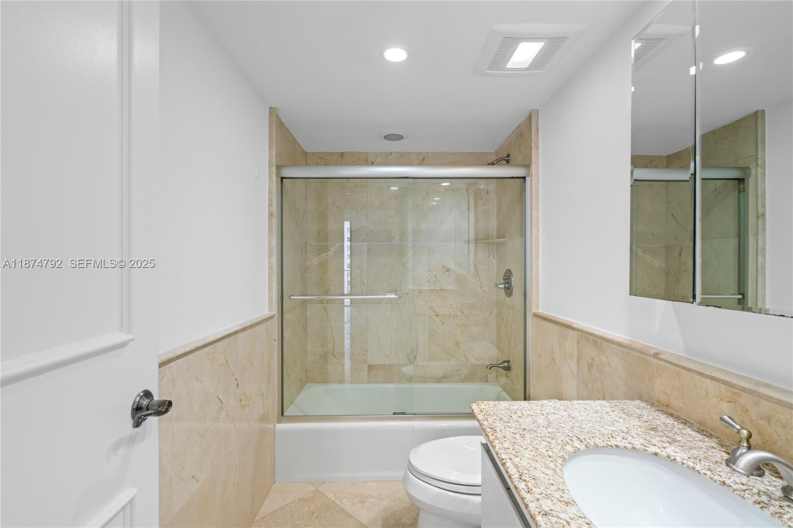 520 Brickell Key Drive, Unit A705 Miami, FL 33131 - Photo 49 of 63 a bathroom with a granite countertop sink a toilet and shower