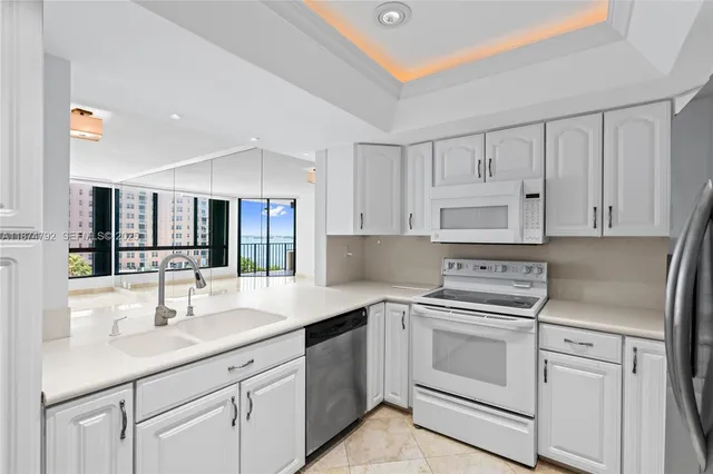 a kitchen with white cabinets and white appliances