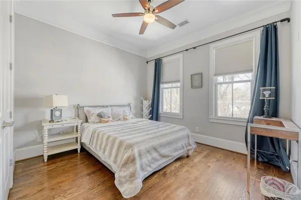 a bedroom with a bed wooden floor and window