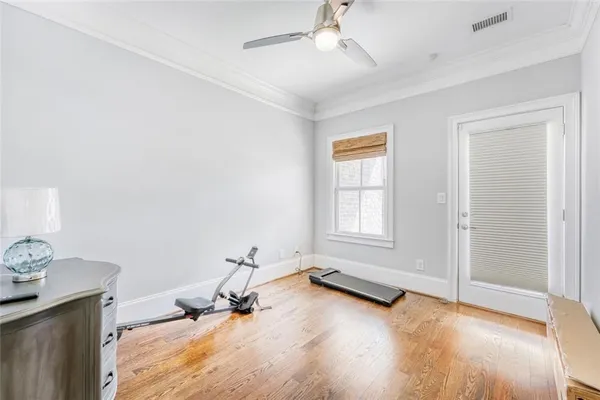 a view of a room with gym equipment and wooden floor