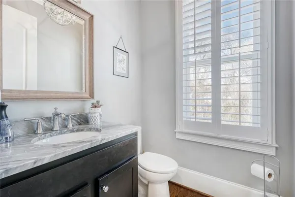 a bathroom with a granite countertop sink toilet and a mirror