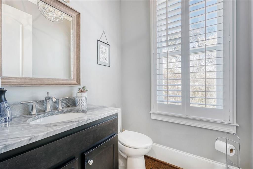 1196 John Collier Road Northwest, Unit 1196 Atlanta, GA 30318 - Photo 4 of 26 a bathroom with a granite countertop sink toilet and a mirror